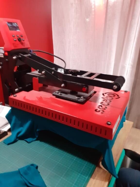 Presse à chaud de l'atelier StylArtis, ouverte sur un t-shirt turquoise