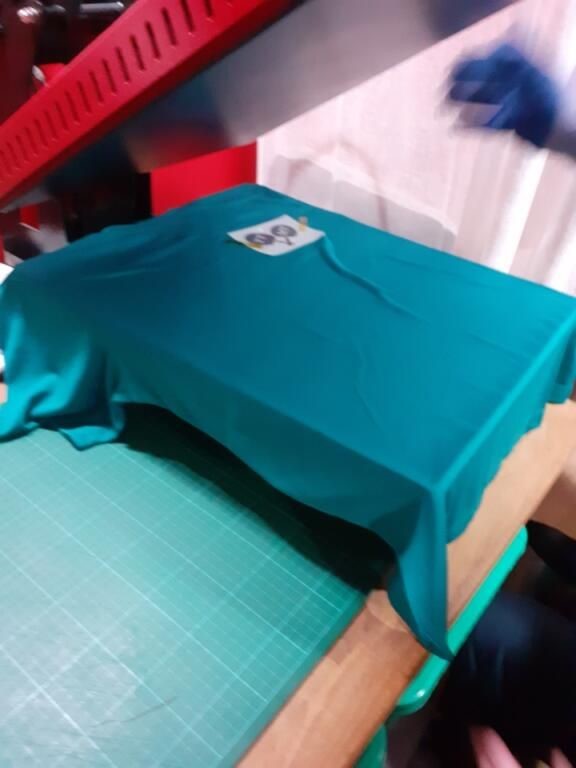 T-shirt turquoise préparé sur la presse, transfert en place avant pressage